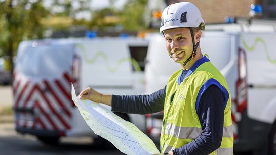 Working sustainably is part of our DNA Fluvius employee with construction plan in hand