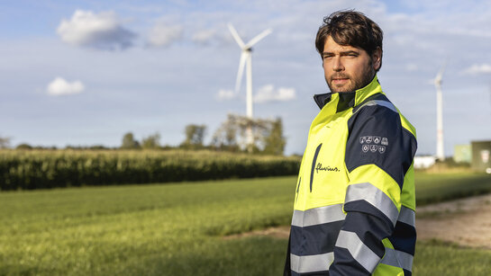Our strategy: the 4 pillars Fluvius employee with windmill in the background
